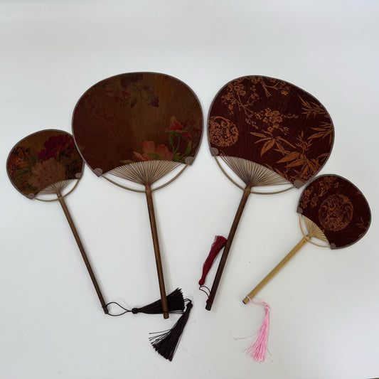 On the white table there are four Japanese round fans (Uchiwa fans), made of Xiangyunsha silk and embroidered with Chinese patterns such as plum blossoms, and bamboo leaves.