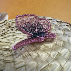 A fake butterfly on a palm leaf fan