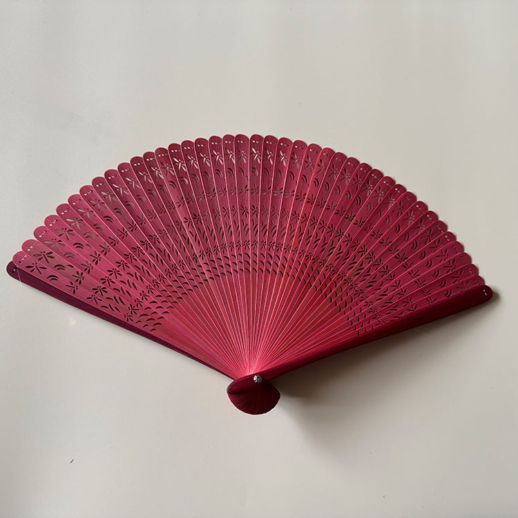 A red touqing bamboo fan on a white surface