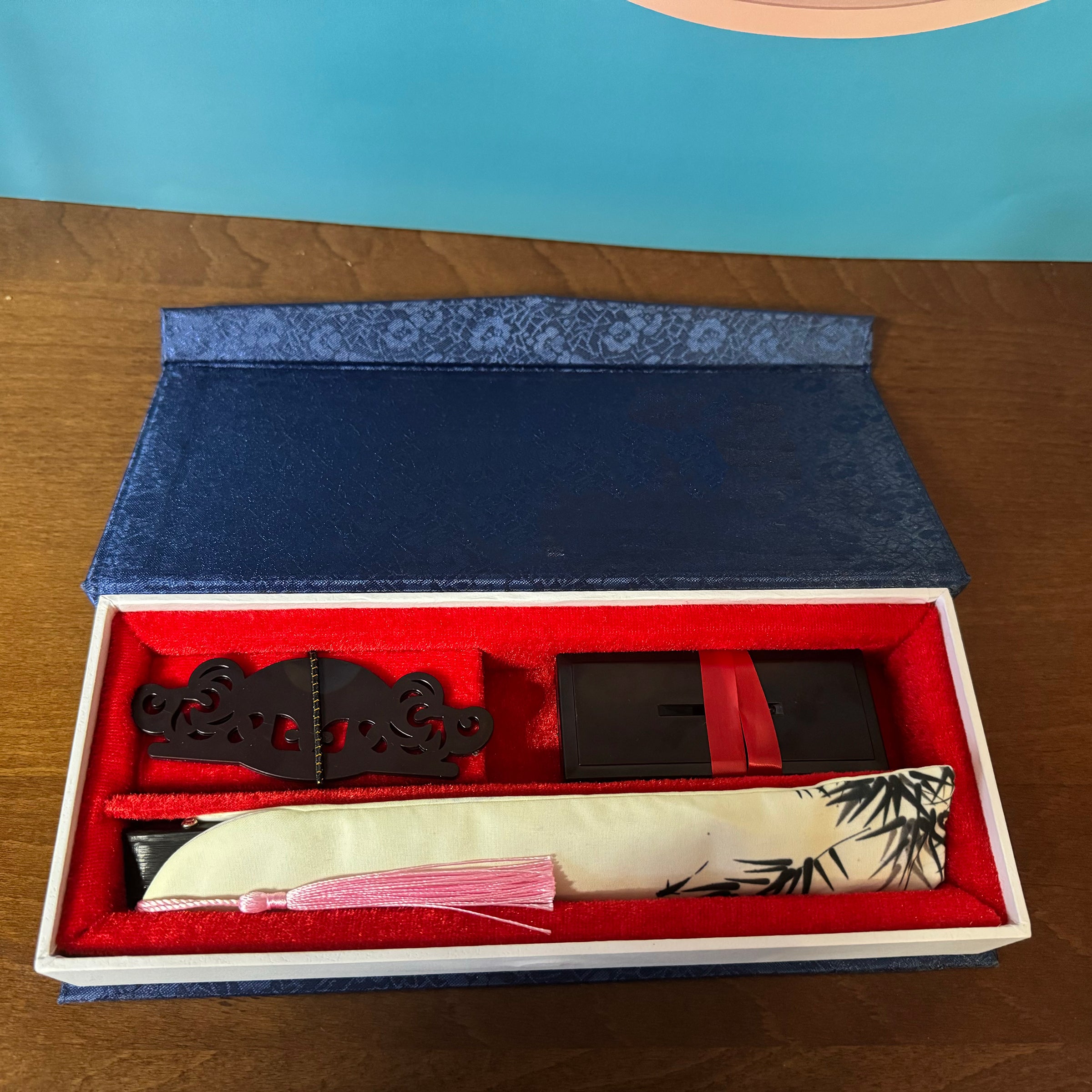 a dark blue box with surface patterns, containing a fan and a fan stand holder inside