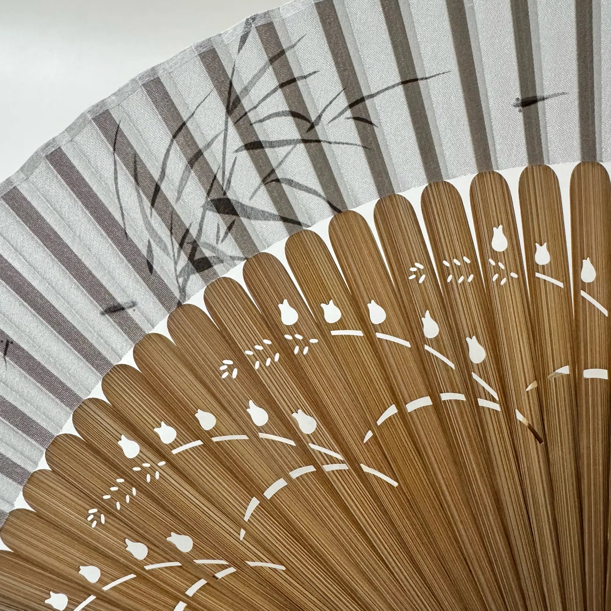 Close-up of the pomegranate flower carving on fan frame and the ink painting of bamboo leaves and fish on fan panel