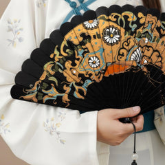 Urushi lacquer folding fan, held by a model wearing elegant traditional Chinese attire.