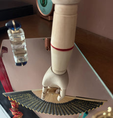 The reflection in the mirror shows a wooden hand holding a zen heart sutra fan