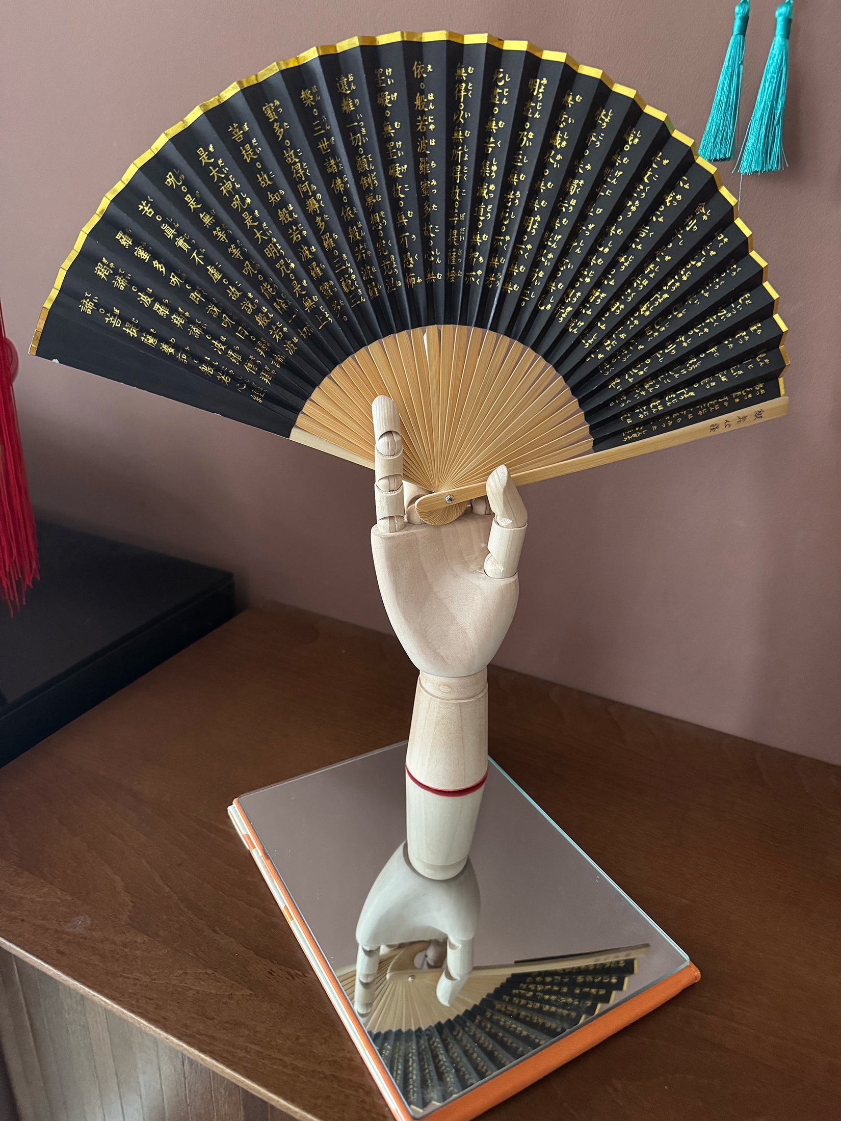 A Zen heart sutra fan placed on a mirror