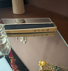 A folded Zen heart sutra fan placed on a mirror