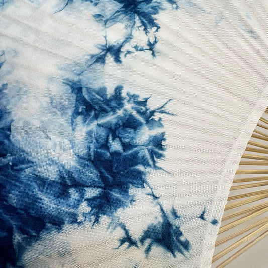 Details of a Japanese round fan with ice flower blue tie-dye print.
