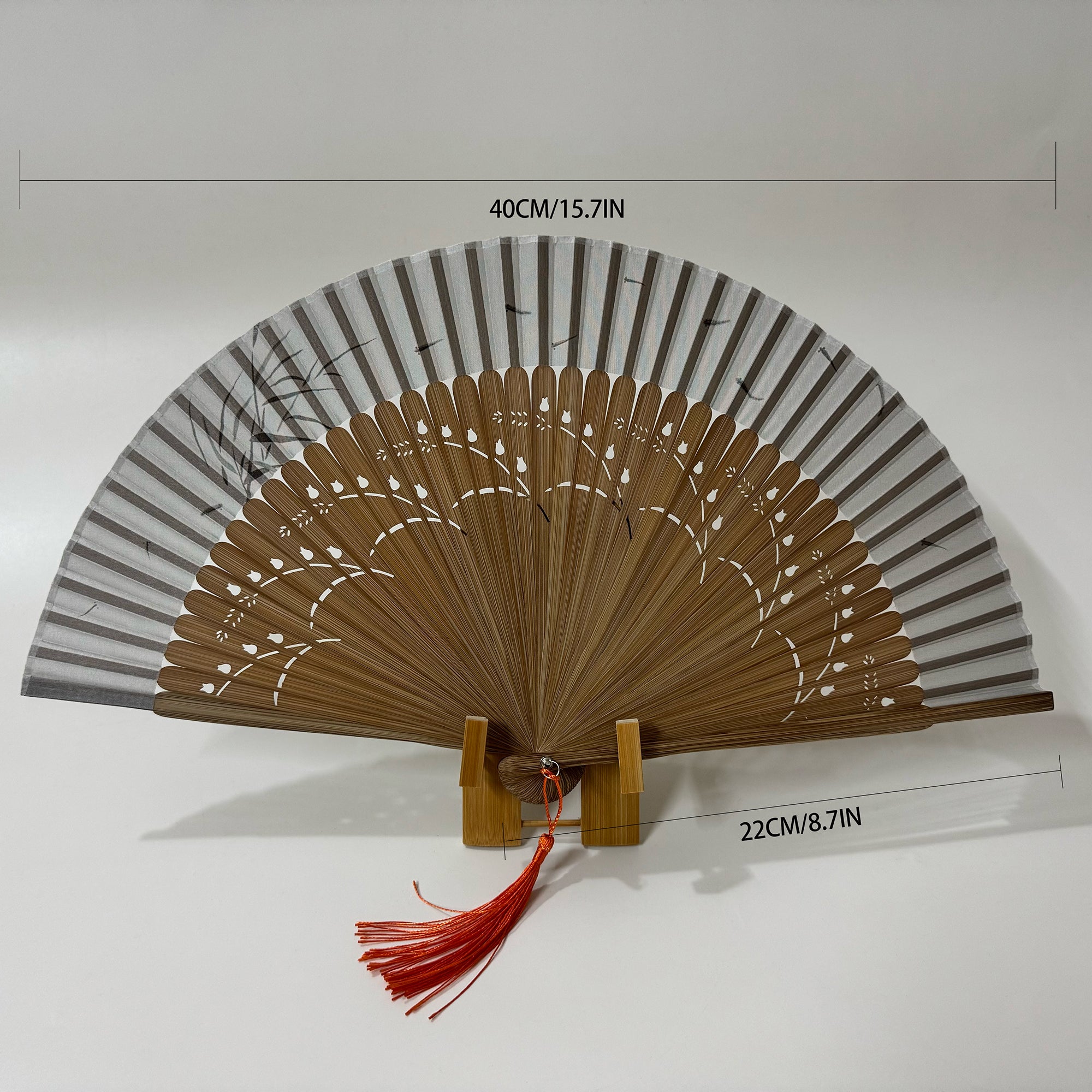 A pomegranate flower carved bamboo folding fan with red tassel. The dimensions of the fan are as shown in the picture.