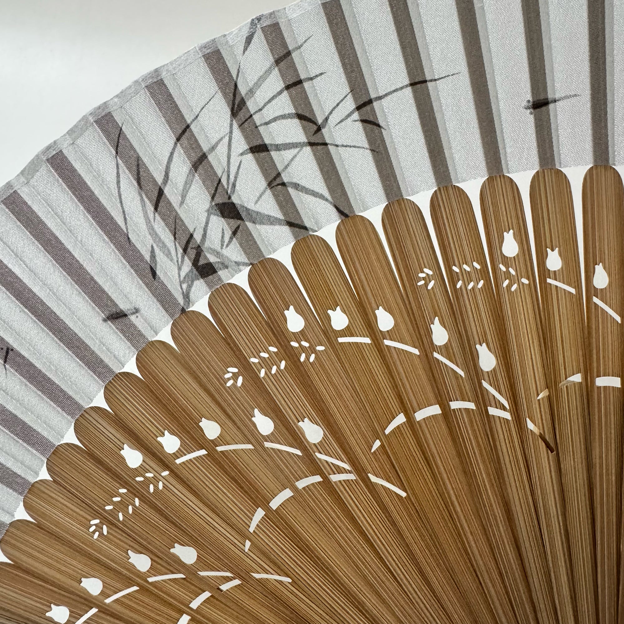 Close-up of the pomegranate flower carving on fan frame and the ink painting of bamboo leaves and fish on fan panel