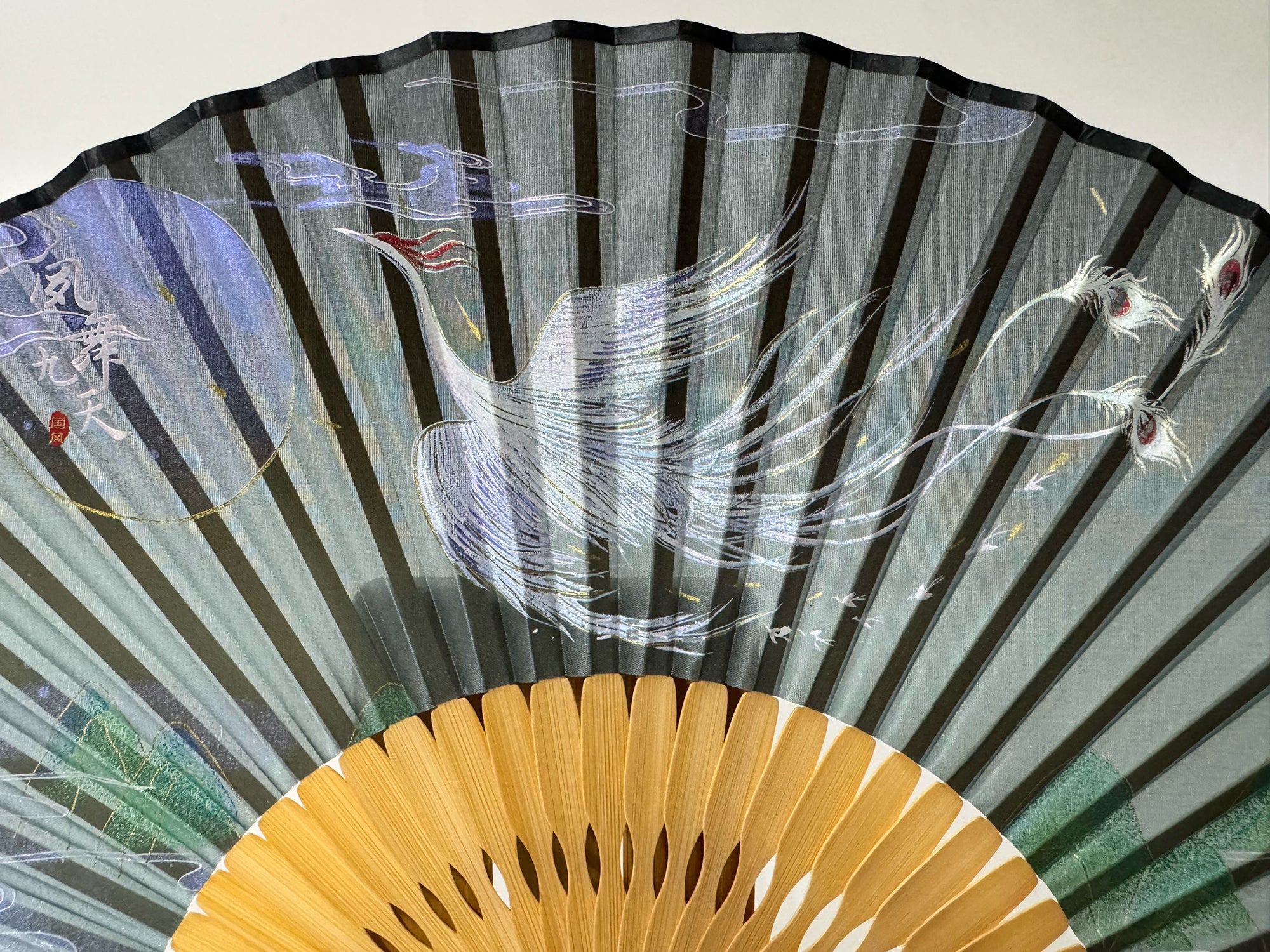 Details of the phoenix printed on a Chinese silk phoenix folding fan.