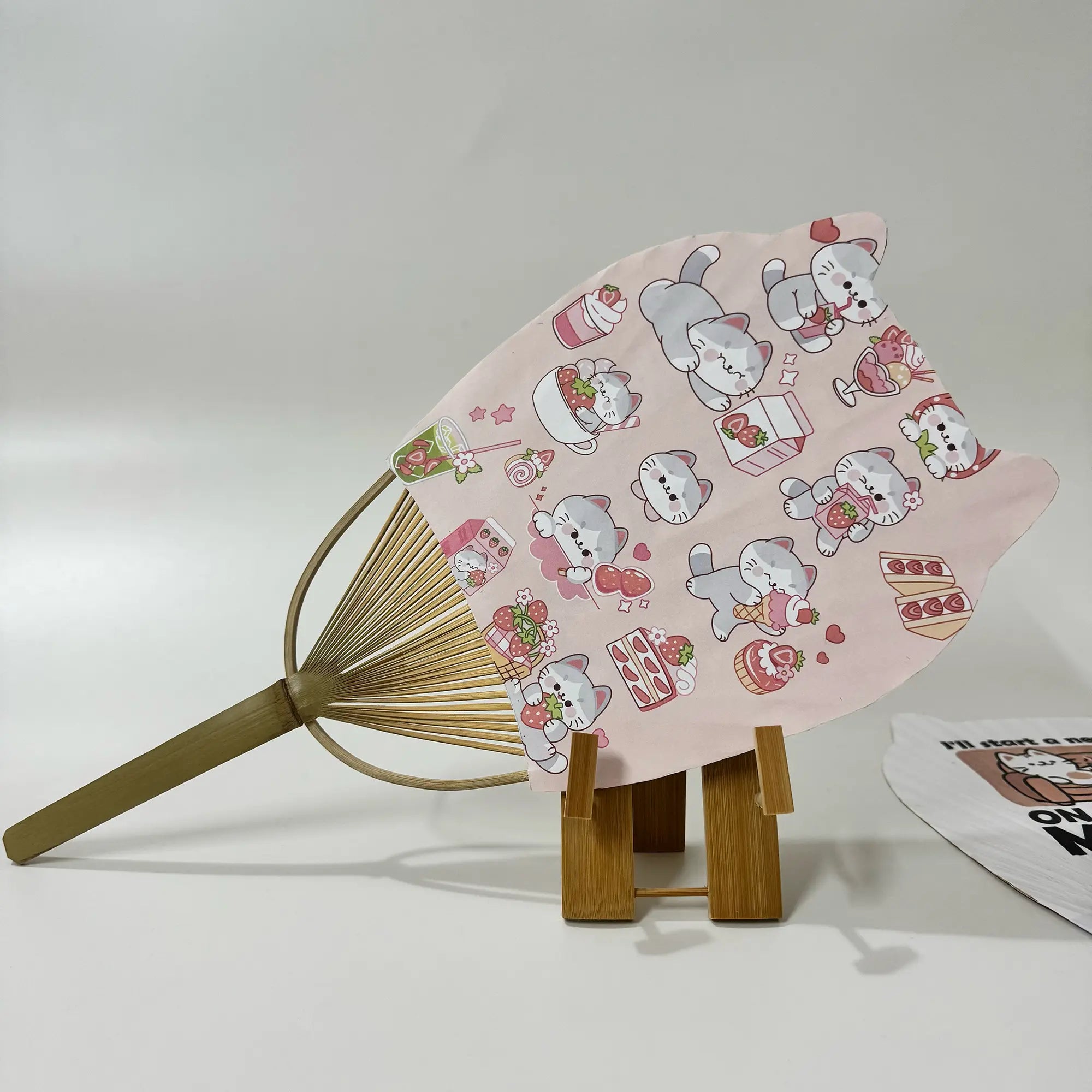 A Japanese round fan (Uchiwa fan) with cat ears. On the fan panel it prints cat pictures.