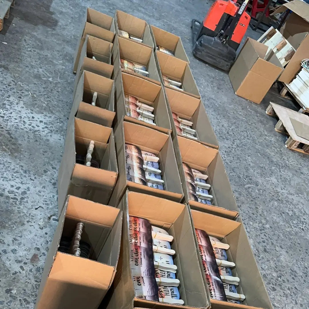 Custom printed promotional hand fans from a factory order. Fifteen packed but unsealed boxes of fans are shown on the factory floor, awaiting sealing before shipment.