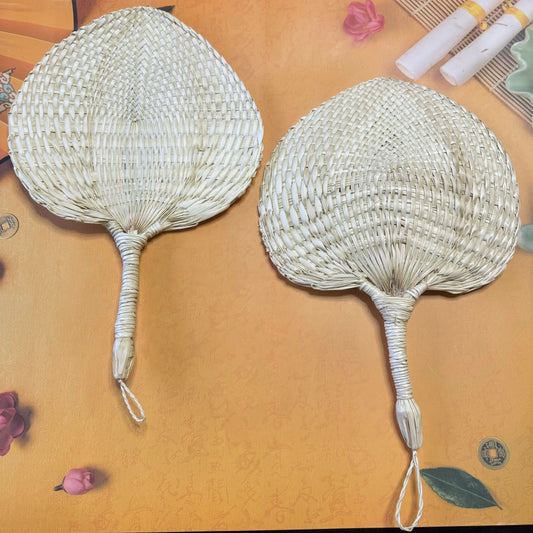 2 middle size palm leaf fans on a surface
