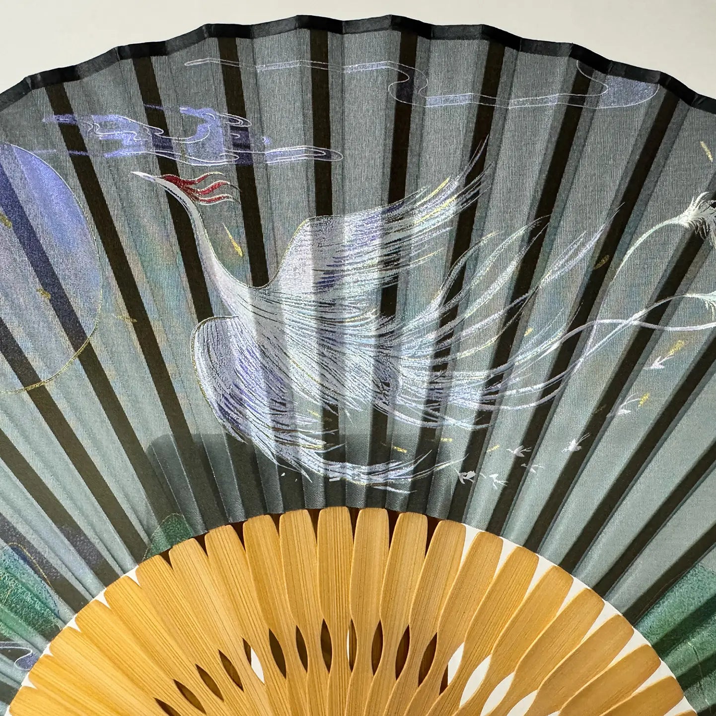 Details of the phoenix printed on a Chinese silk phoenix folding fan.