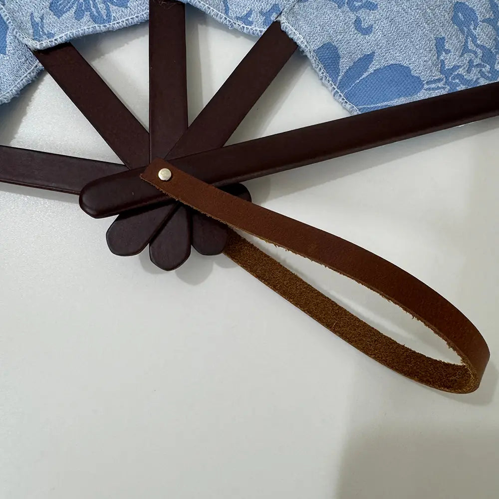 Details of the sturdy fan frame and supple leather wrist strap, blue embroidered hand fan.