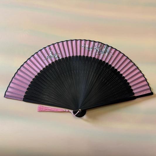 A folding fan with Traditional Chinese Plum Blossom Painting on a white surface